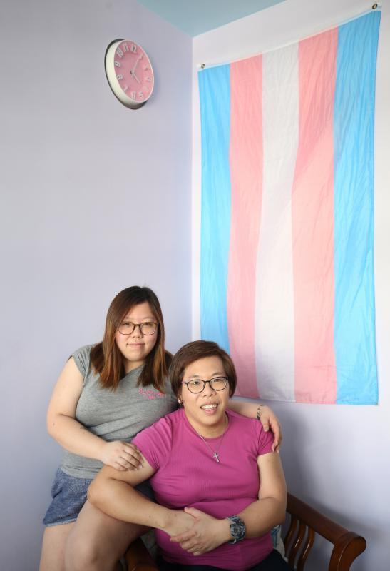对吕惠婷(左)来说,吕芬倪既是母亲,也是父亲。她们背后挂着一面代表跨性别者的旗帜。