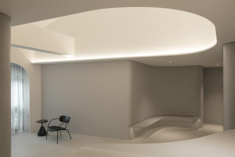 设计师将原有的假天花板拆掉，还原客厅的高度，灯光照向的挑高天花板变成柔和的光池。