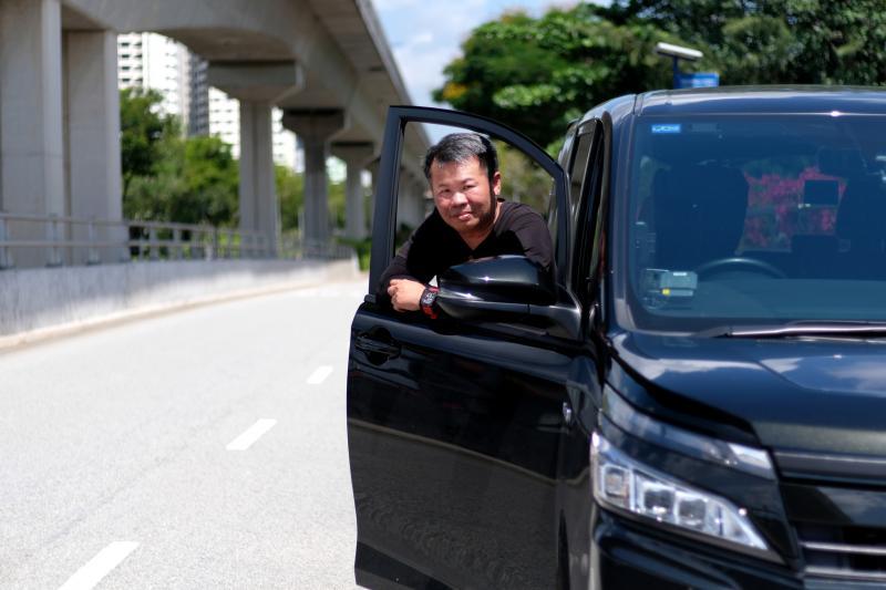 私召车司机吴奇辉参加GrabCare服务，放下社会偏见，接送本地医护人员上下班。（龙国雄摄）