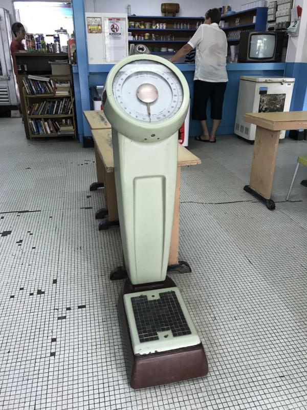 老秤磅和旧款电视如出土文物,左侧的木藤书架放置顾客留下的书籍。