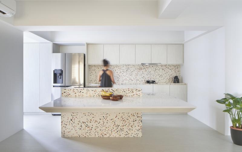 设计师将水磨石延伸进厨房，打造中岛式餐桌与壁橱墙壁。