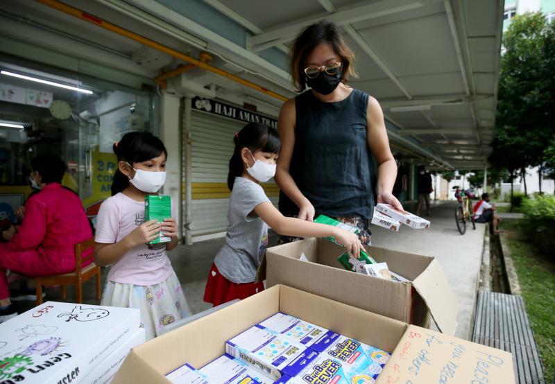 叁南瓜创办人林诗韵(右)与小朋友非常熟络,有些小朋友直接称呼她Teacher。3P Community Arts Lab外有饼干、口罩和纸板游戏,任小朋友和街坊免费领取。