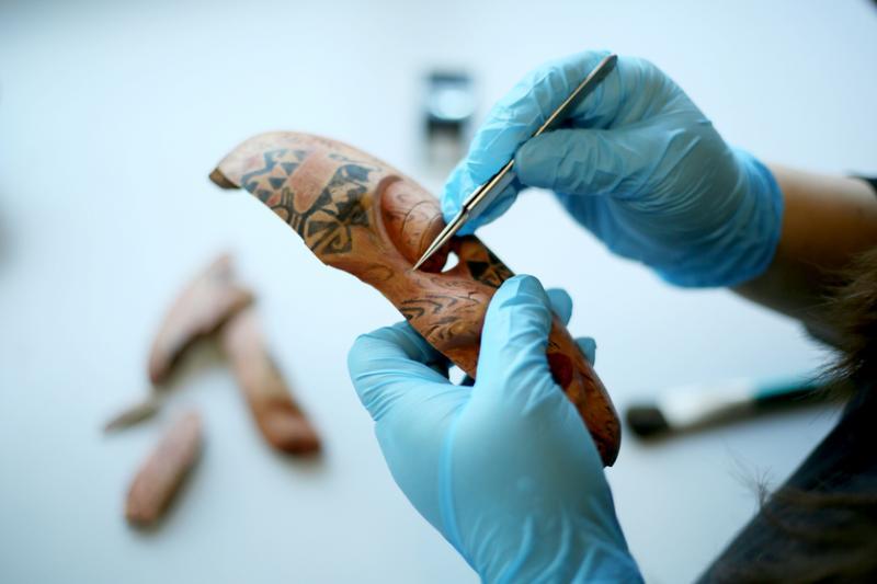 用针头刀清除附在文物表面的微小杂质,很考眼力和腕力。(龙国雄摄)