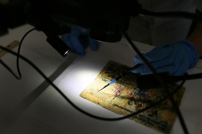 纸质文物常有胶带,需要用小锉刀来分开。(龙国雄摄)