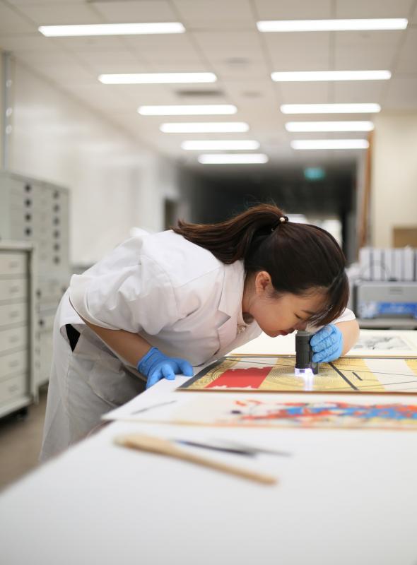 许珍琪需要借用显微放大器材,修复纸质文物肉眼看不到的破损。(龙国雄摄)