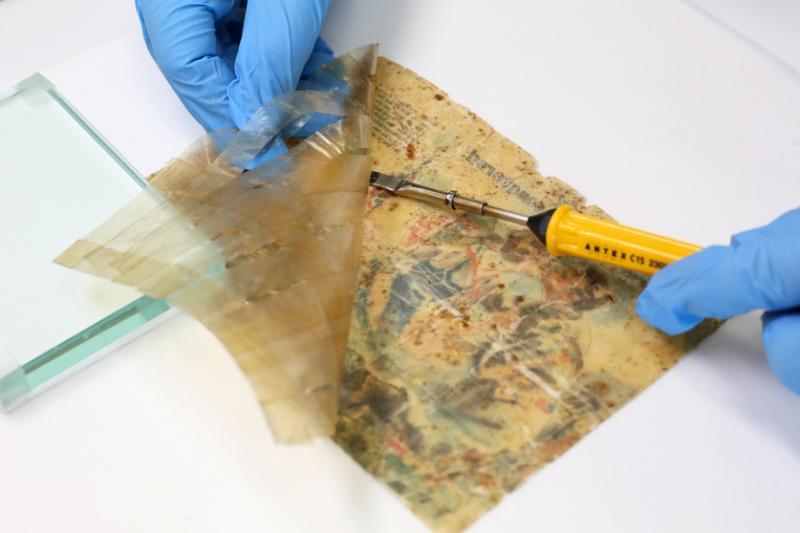 这张二战时日军空投的劝降宣传单背后粘满胶带,须小心除去。(龙国雄摄)