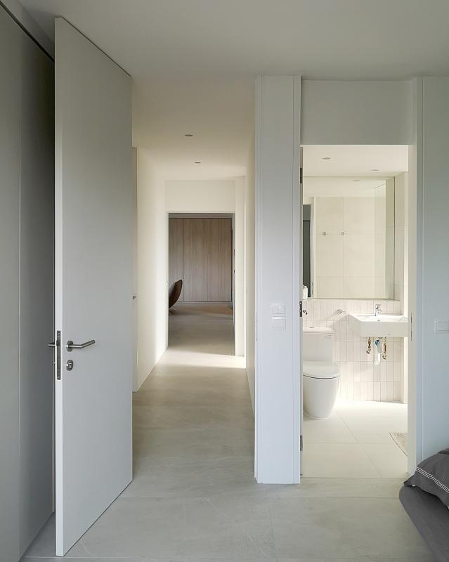 主人房的门口与全屋的延续性衔接,从客厅饭厅到卧房的整体建筑语言非常一致,强调了简约和纯净。