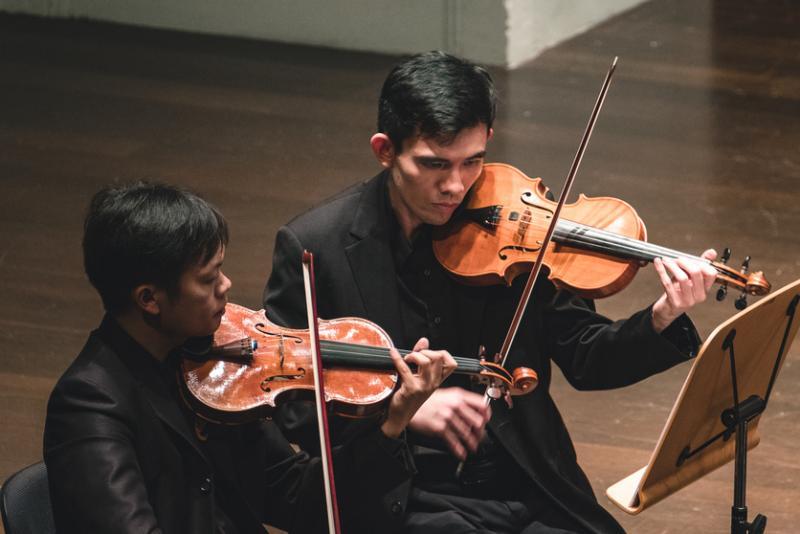 王韶军(右)参与业余乐团的演出,2018年5月在维多利亚音乐厅合奏小提琴。(受访者提供)