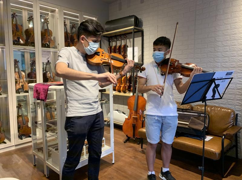 王韶军在工作室兼琴行里教琴,学员从小学生到成人。(受访者提供)