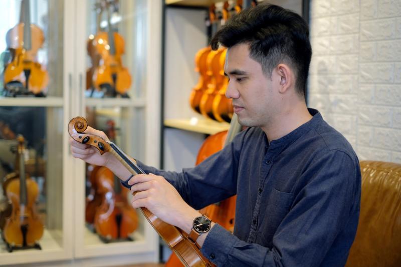 王韶军的琴行有多把百年老琴,老琴具珍藏价值,但要保养得当。他正为老琴调音。