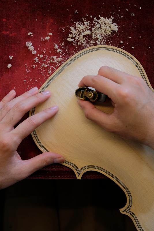 制作提琴从木板分割、刨板、镶线,到木的年轮分布,都马虎不得。左手食指上留下的缝针痕迹,更提醒王韶军制琴过程需要全神贯注。
