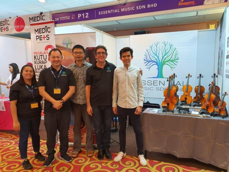 王韶军(右一)到文莱为自己制作的小提琴开拓市场。(受访者提供)