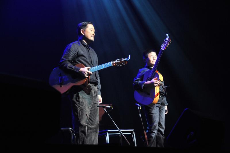 娄宝宏(左)和娄楷文父子在2009年儿童慈善音乐会上演出。(受访者提供)