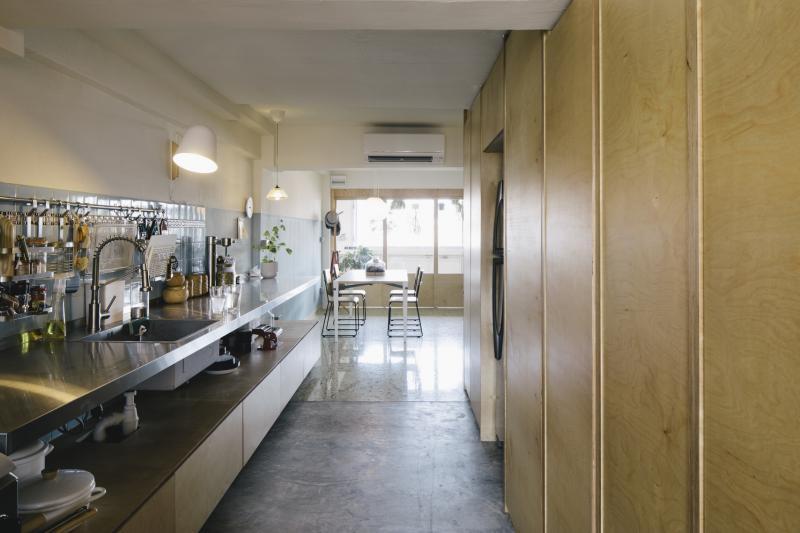 设计师和屋主选择了开放式、可移动的厨房家具:极长的木柜,上面做了相同长度的不锈钢料理台,中间开放的橱架和料理台摆放屋主精美的厨具、碗盘等。