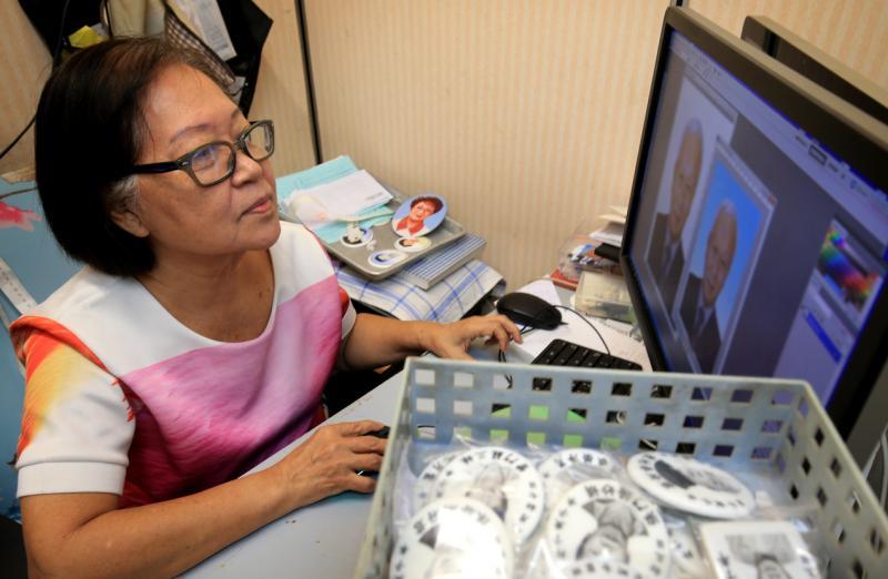 陈桂珍用电脑修图制作瓷相。（龙国雄摄）