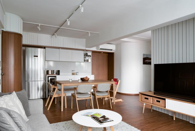 客厅空间不大，设计师把干厨房缩小成食品储藏柜，与冰箱并排，就放得下一张大餐桌了。