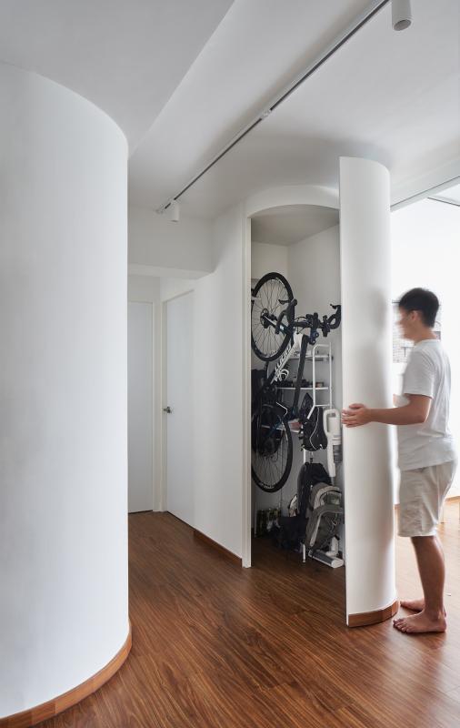 书房的另一面弧形墙的板门后原来是一个储藏空间，可收放男主人的脚踏车、其他运动器材和杂物。