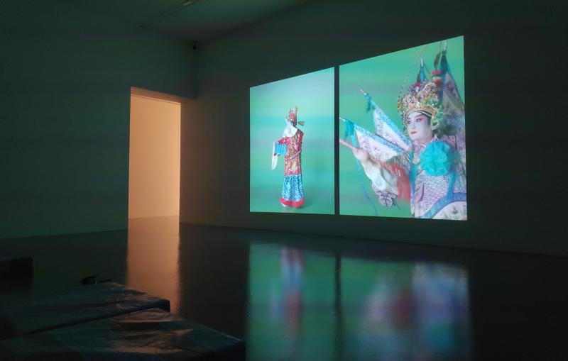 “火热的寺庙”个展展厅的一面墙上,播放着沈炜竣身穿文武生戏服的双频道录像表演。