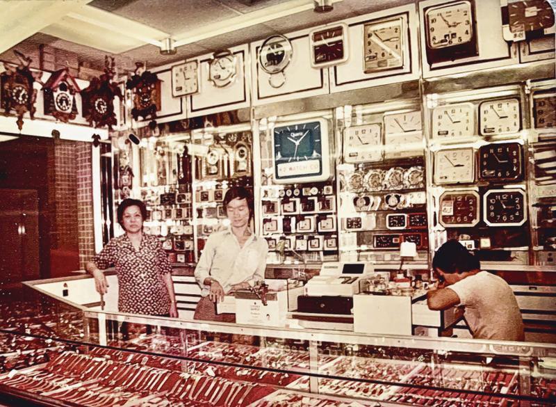 吴成茂(左二)与母亲、哥哥80年代在“克都钟表”店铺留影。(受访者提供)