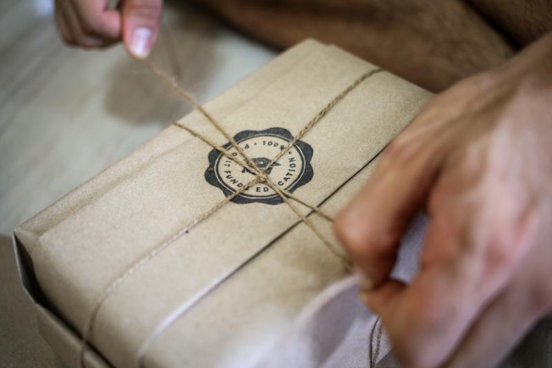 顾客上网订书后，张轫达小心翼翼把书本包好。