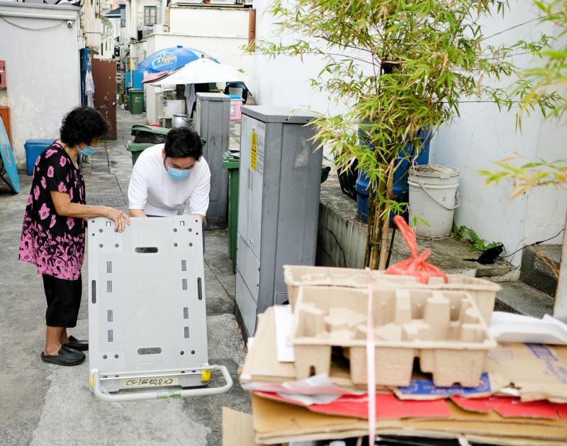 收到义工送来的新推车,方金兰满心欢喜。(曾坤顺摄)