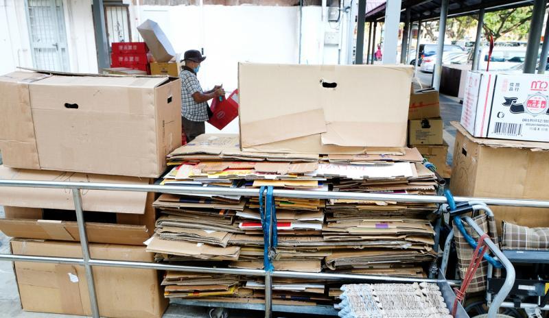 王振吉一天会下楼好几次,把纸箱割开摊平后整理排好。(曾坤顺摄)