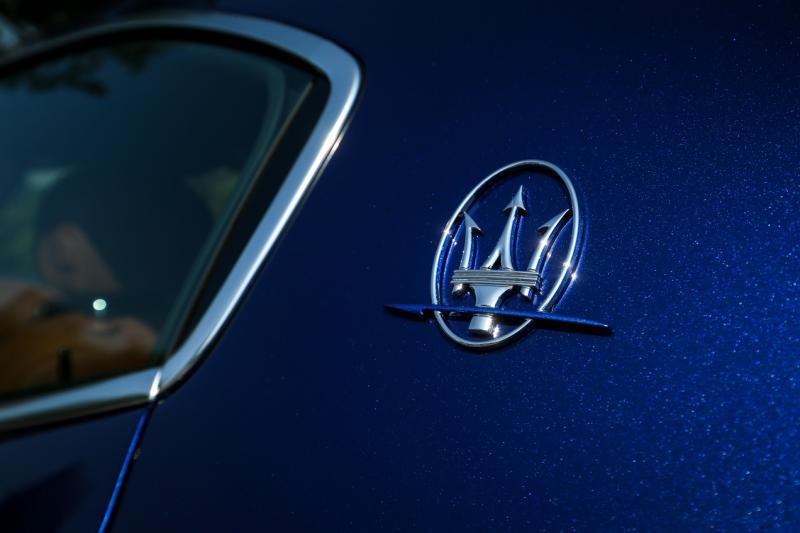 三叉戟厂徽下的一条蓝线，显示这是混合动力车型。