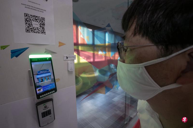 人力资源管理软件公司JustLogin开发以面部识别技术开门的系统,它能自动量体温,并为员工进行SafeEntry登记和打卡。(陈来福摄) 人力资源管理软件公司JustLogin开发以面部识别技术开门的系统,它能自动量体温,并为员工进行SafeEntry登记和打卡。(陈来福摄)