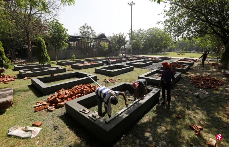 印度冠病死亡病例不断升高,各地火葬场挤压了不少遗体,图为工人昨天在首都新德里增建焚化台,以加快处理遗体的速度。(路透社) 印度冠病死亡病例不断升高,各地火葬场挤压了不少遗体,图为工人昨天在首都新德里增建焚化台,以加快处理遗体的速度。(路透社)