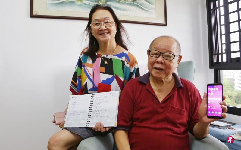 吴美英(左)到新加坡数码转型社区援助站学习数码技能,并在笔记本上记下每个应用使用的步骤。经常陪同太太到援助站学习的林明计(右)认为数码大使都是非常好的老师。(白艳琳摄) 吴美英(左)到新加坡数码转型社区援助站学习数码技能,并在笔记本上记下每个应用使用的步骤。经常陪同太太到援助站学习的林明计(右)认为数码大使都是非常好的老师。(白艳琳摄)