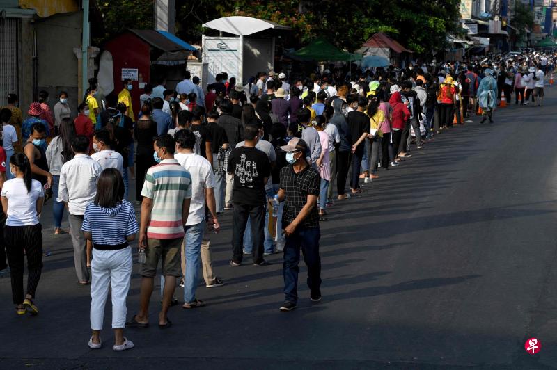 为了遏制冠病疫情，柬埔寨民众响应政府号召，纷纷前往金边一所学校排队轮候接种疫苗。（法新社）