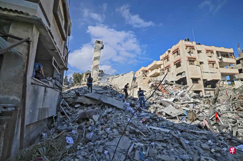 以色列周二早上继续对加沙地区展开空袭。图为一群巴勒斯坦人在一栋被炸毁的建筑物外面,于废墟中寻找可用的物品。以巴双方连日武装冲突造成的伤亡日益严重,鉴于冲突持续加剧,联合国安理会将召开紧急会议共商对策。(法新社) 以色列周二早上继续对加沙地区展开空袭。图为一群巴勒斯坦人在一栋被炸毁的建筑物外面,于废墟中寻找可用的物品。以巴双方连日武装冲突造成的伤亡日益严重,鉴于冲突持续加剧,联合国安理会将召开紧急会议共商对策。(法新社)