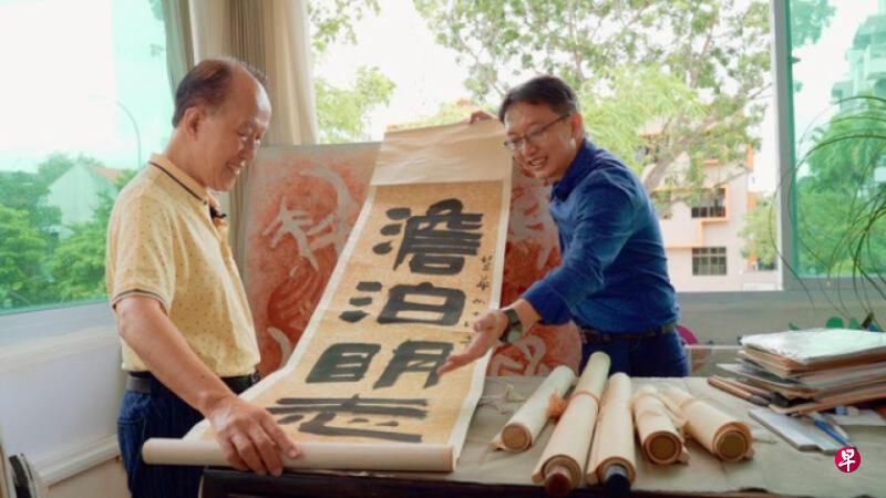 书法家崔大地高足杨昌泰(左)跟“南洋大师”线上系列主持人陈志锐分享其恩师的隶书墨宝。(受访者提供) 书法家崔大地高足杨昌泰(左)跟“南洋大师”线上系列主持人陈志锐分享其恩师的隶书墨宝。(受访者提供)