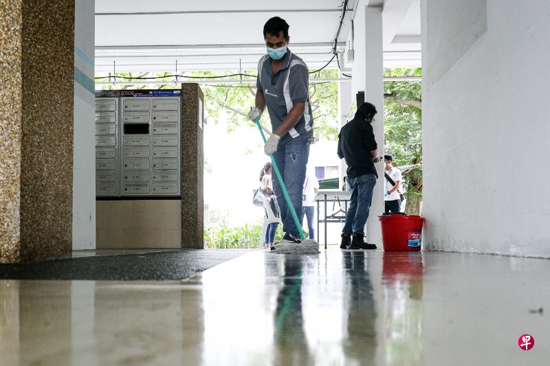 清洁工在冠病检测活动开始前,为后港8道第506座组屋进行多一轮的清洁和消毒。(李健玮摄) 清洁工在冠病检测活动开始前,为后港8道第506座组屋进行多一轮的清洁和消毒。(李健玮摄)