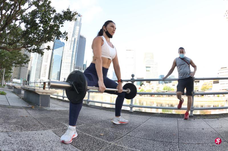 Fitness Factory联合创办人李光雄(右)把运动器材搬到户外,一对一指导学员缇米雅在新加坡河畔锻炼肌肉。(邬福梁摄) Fitness Factory联合创办人李光雄(右)把运动器材搬到户外,一对一指导学员缇米雅在新加坡河畔锻炼肌肉。(邬福梁摄)
