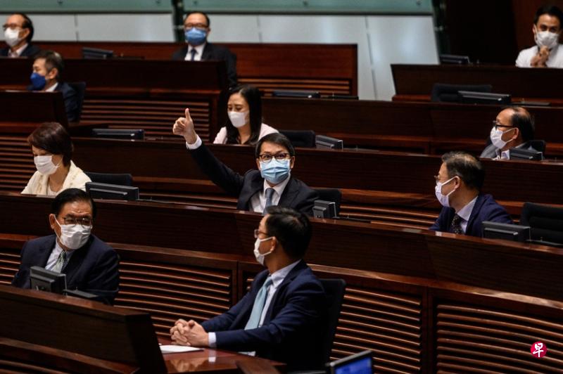 香港立法会昨天通过《2021年完善选举制度(综合修订)条例草案》后,民建联议员陈克勤在座位上兴高采烈地竖起大拇指向媒体示意。(法新社) 香港立法会昨天通过《2021年完善选举制度(综合修订)条例草案》后,民建联议员陈克勤在座位上兴高采烈地竖起大拇指向媒体示意。(法新社)