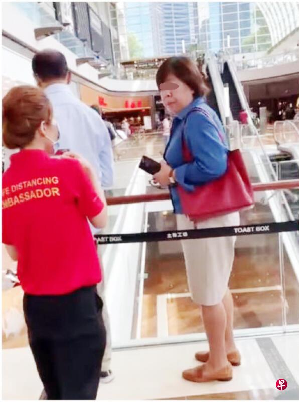 身穿制服的安全大使上前劝蓝衣中年女子戴上口罩。(档案照) 身穿制服的安全大使上前劝蓝衣中年女子戴上口罩。(档案照)