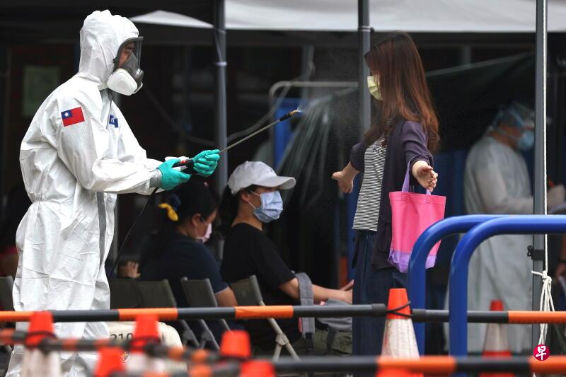 化学兵今天在台北为离开冠病检测点的民众消毒。(路透社) 化学兵今天在台北为离开冠病检测点的民众消毒。(路透社)