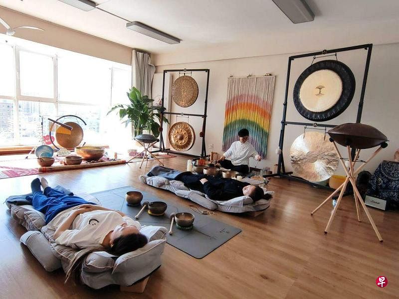 疗愈师李艳在位于北京东三环的壹衍自然疗法工作室里用颂钵为客人做疗愈。（孟丹丹摄）