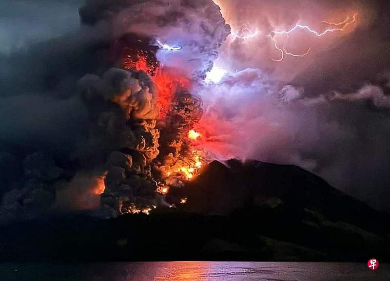 印尼拉翁（Ruang）火山爆发，熔岩四溅，在闪电的映衬下相当骇人。（法新社）