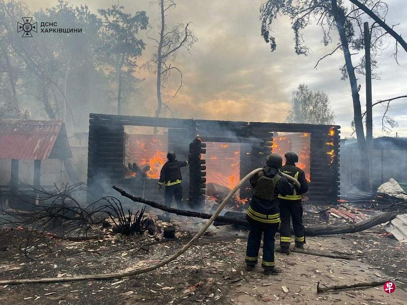 4月21日，乌克兰赫尔松遭到袭击，救援人员在灭火。（法新社）