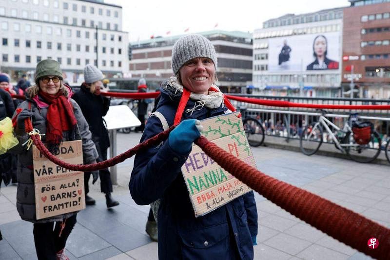 为响应“妈妈们的起义”（Mothers Rebellion）的号召，瑞典数百名妇女手持由3000条小围巾织成的一条特长围巾，在议会周围游行。（路透社）