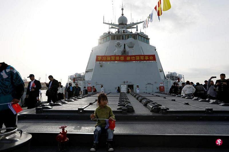 中国官方上周六（4月20日）邀请多国媒体访问海防重镇青岛，并开放贵阳舰等海军舰艇供外媒参观。图为开放日活动中，一名孩童坐在贵阳舰的甲板上。（路透社）