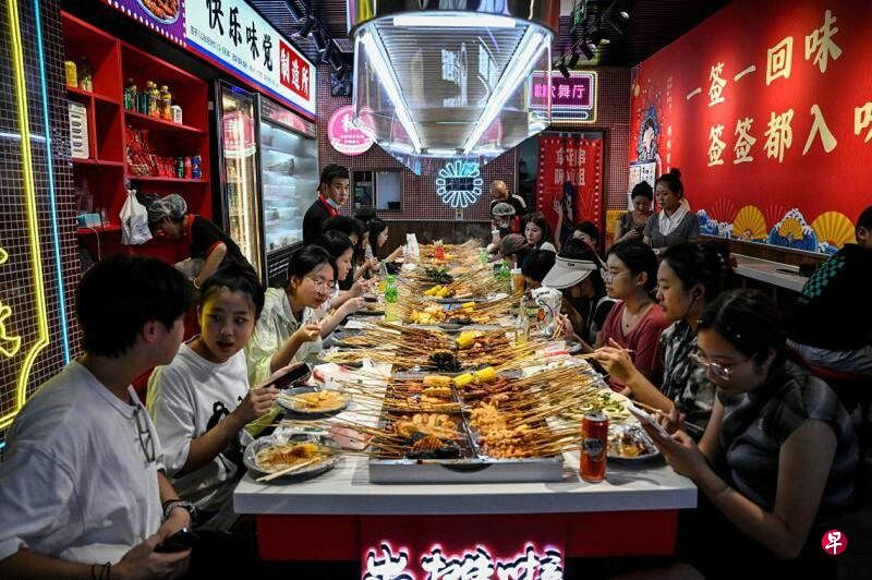 近两年中国“穷鬼套餐”风越刮越大，“穷鬼”的领域也从最初的洋快餐横跨到其他餐饮消费。图为中国年轻人在北京商场内的一家餐厅用餐。（法新社）