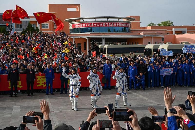 中国神舟十八号载人飞行任务航天员（左起）李广苏、李聪和叶光富星期四（4月25日）在登上飞船前的出征仪式上挥手致意。（法新社）