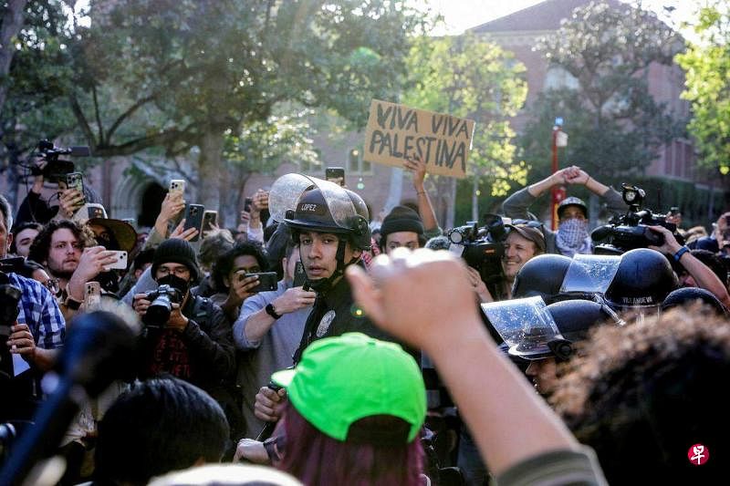 4月24日，南加州大学学生在校内扎营抗议，声援巴勒斯坦。洛杉矶警方在人群中维持秩序。（路透社）