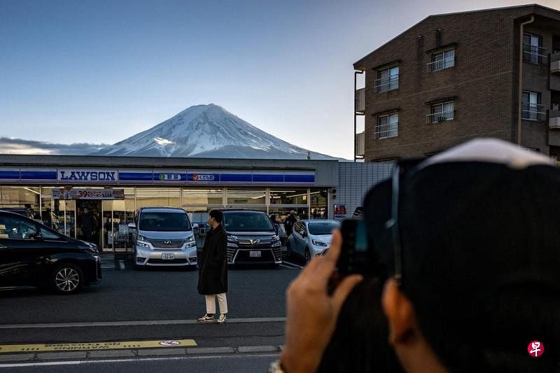 因不满大批外国游客的恶劣行为，日本富士山一小镇决定在一个热门拍照地点设立一面巨大黑色屏障，遮挡富士山的美景。（法新社）