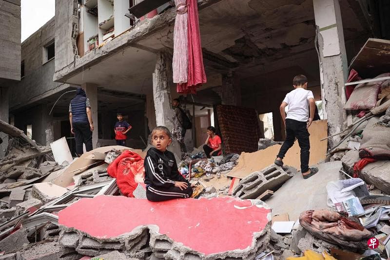 4月27日，在加沙南部城市拉法，巴勒斯坦儿童在被以军空袭摧毁的房屋废墟中出没。（法新社）