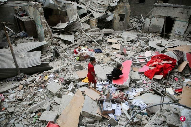 4月27日，加沙南部城市拉法遭以色列袭击，巴勒斯坦儿童在一座被摧毁的房屋废墟上。（路透社）