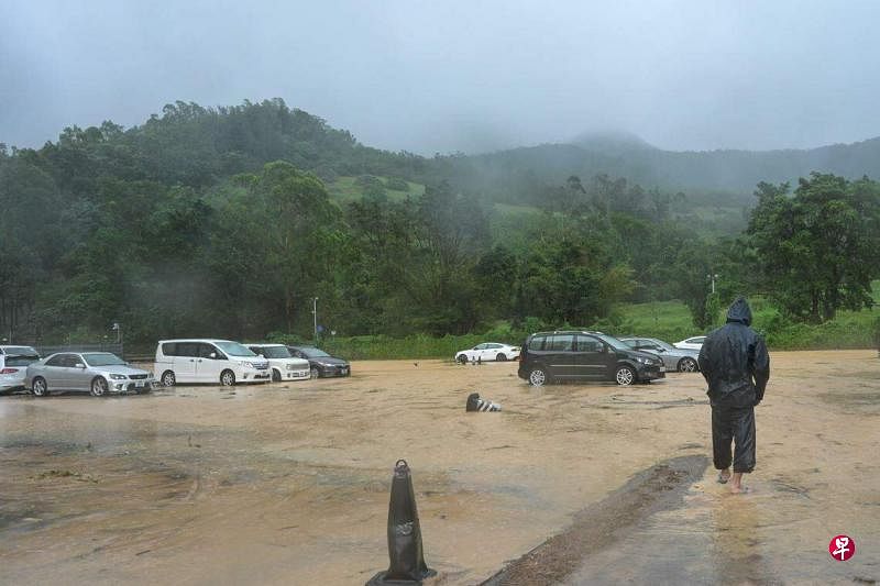 红色暴雨下，香港将军澳有停车场一度淹水，市民涉水而行。（中新社）